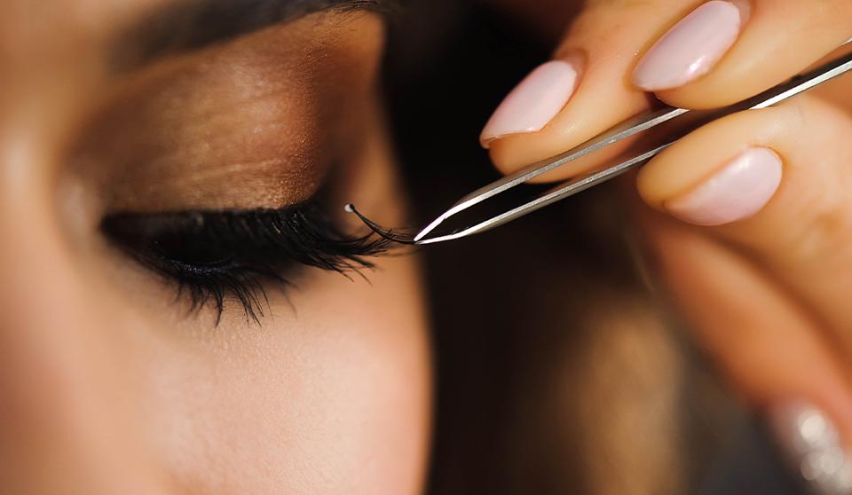 close up of a woman getting lash extensions put on one salon beauty services